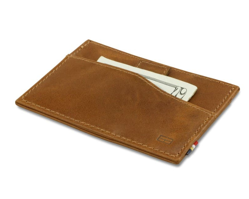 Front view of Leggera Card Holder Brushed in Brushed Cognac with a pull tab with money.