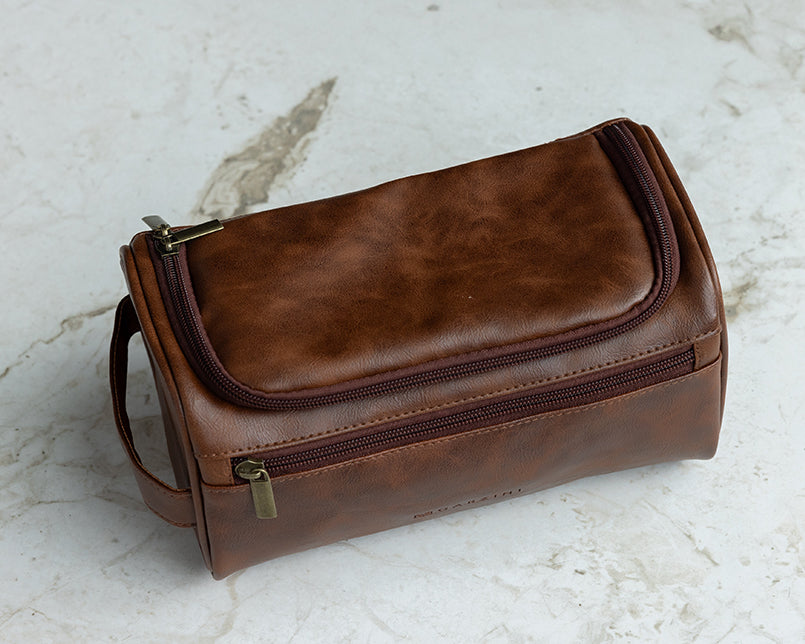 Brown Garzini Toiletry Bag in a modern bathroom setting, showcasing its practicality and luxury for organized travel.