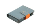 Closed Garzini Metal Wallet in blue leather with snap button and orange strap, viewed from an angle