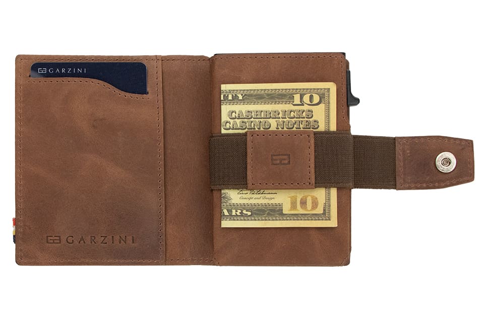Open Garzini Metal Wallet in brushed brown leather, holding a stack of cash