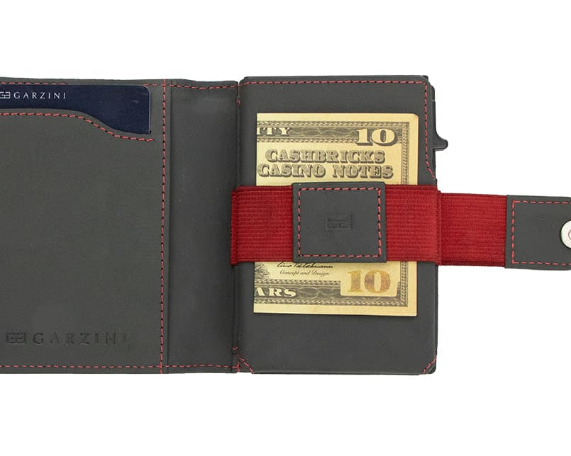 Open Garzini Metal Wallet in carbon red leather, holding a stack of cash