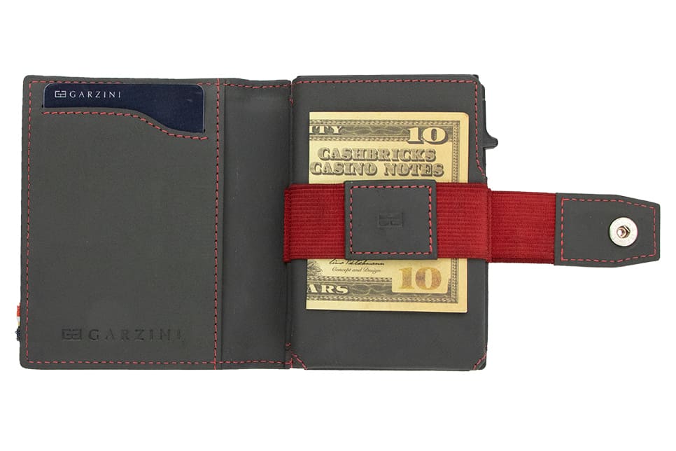 Open Garzini Metal Wallet in carbon red leather, holding a stack of cash
