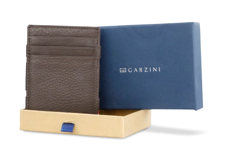 Half-open green box with Garzini brand name, featuring Nappa icons. Inside the box, the Nappa Chocolate Brown wallet is wrapped in tissue paper, placed in a light cardboard box with a green strap.