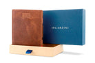 Half-open blue box with Garzini brand name Inside the box, the Brushed Brown wallet is wrapped in tissue paper, placed in a light cardboard box with a blue strap.