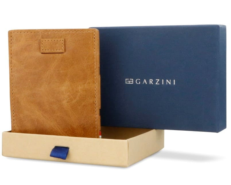 Half-open blue box with Garzini brand name Inside the box, the Brushed Cognac wallet is wrapped in tissue paper, placed in a light cardboard box with a blue strap.