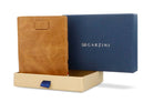 Half-open blue box with Garzini brand name Inside the box, the Brushed Cognac wallet is wrapped in tissue paper, placed in a light cardboard box with a blue strap.