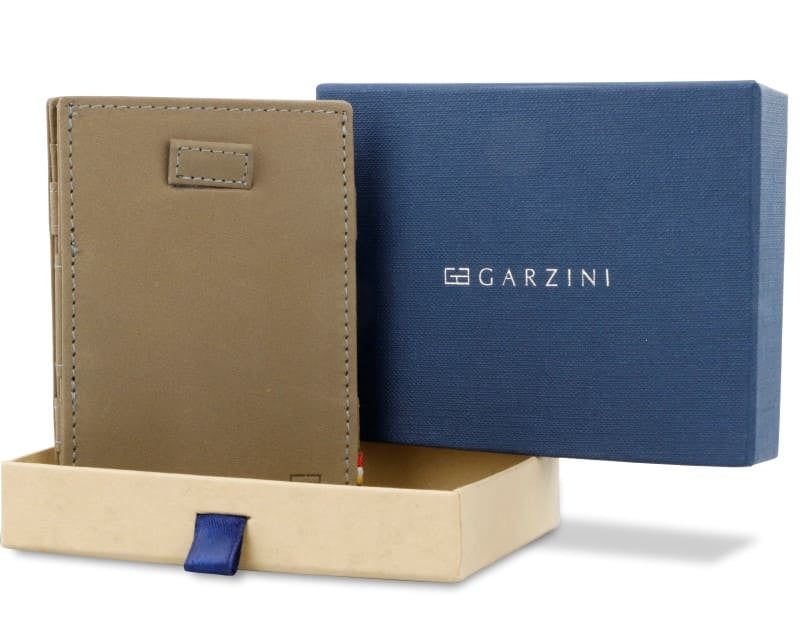 Half-open blue box with Garzini brand name Inside the box, the Metal Grey wallet is wrapped in tissue paper, placed in a light cardboard box with a blue strap.