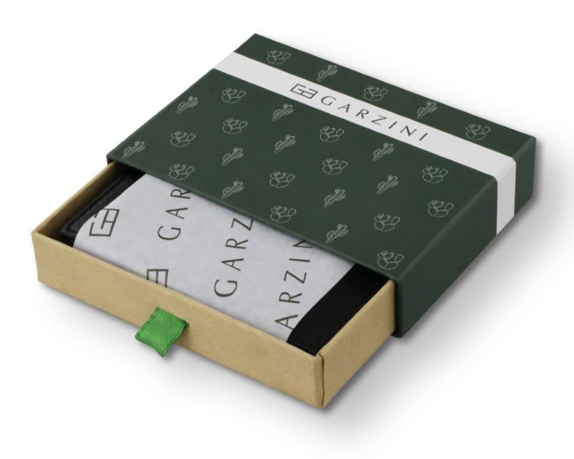 Half-open green box with Garzini brand name, featuring cactus icons. Inside the box, the cactus black wallet is wrapped in tissue paper, placed in a light cardboard box with a green strap.