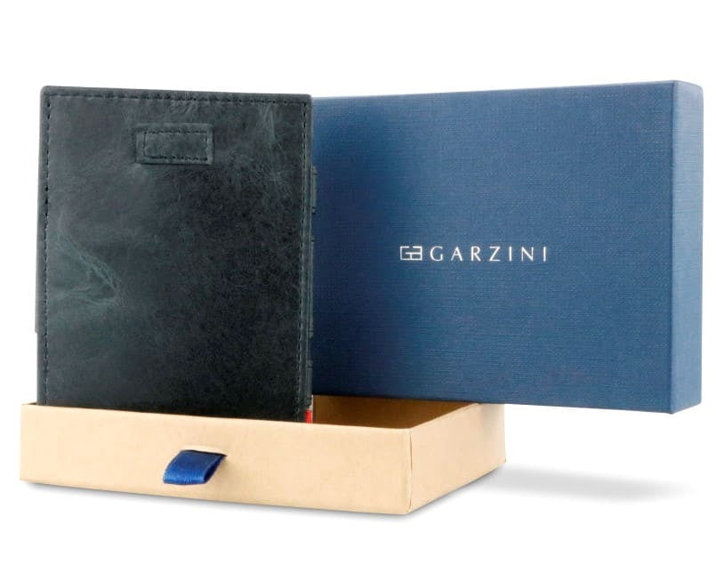 Half-open blue box with Garzini brand name Inside the box, the Brushed Black wallet is wrapped in tissue paper, placed in a light cardboard box with a blue strap.