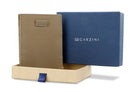 Half-open blue box with Garzini brand name Inside the box, the Metal Grey wallet is wrapped in tissue paper, placed in a light cardboard box with a blue strap.