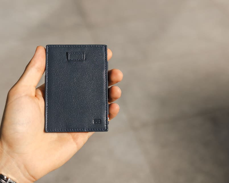 A hand holding the Garzini Cavare Navy Blue nappa wallet