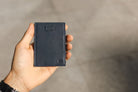 A hand holding the Garzini Cavare Navy Blue nappa wallet