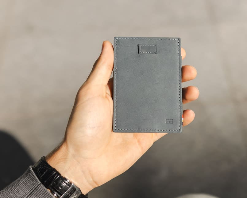 A hand holding the Garzini Cavare Sapphire Blue wallet