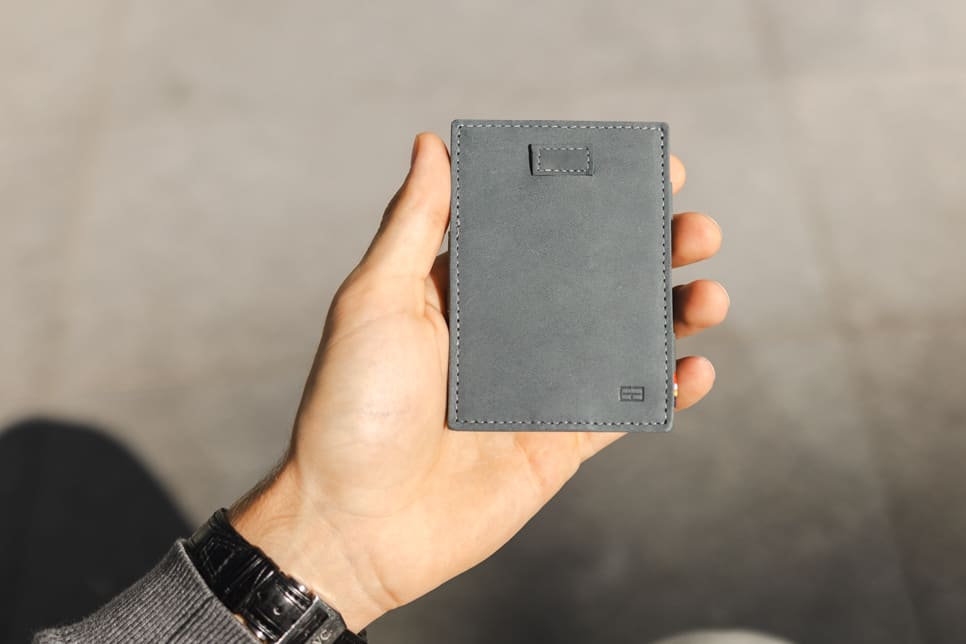 A hand holding the Garzini Cavare Sapphire Blue wallet