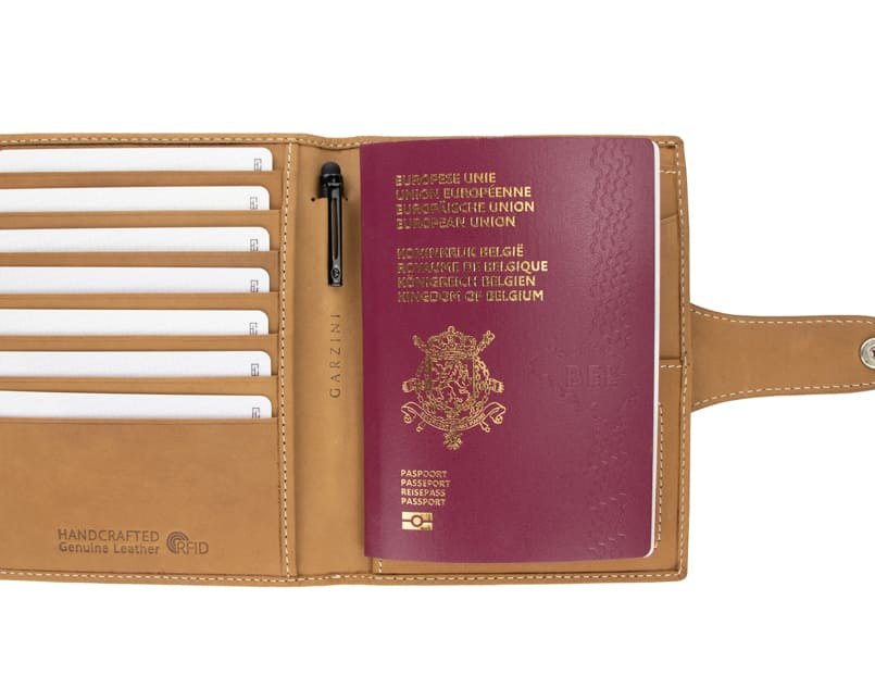 Open view of the AirTag Passport Holder in Vintage Camel Brown with cards and passport inside.