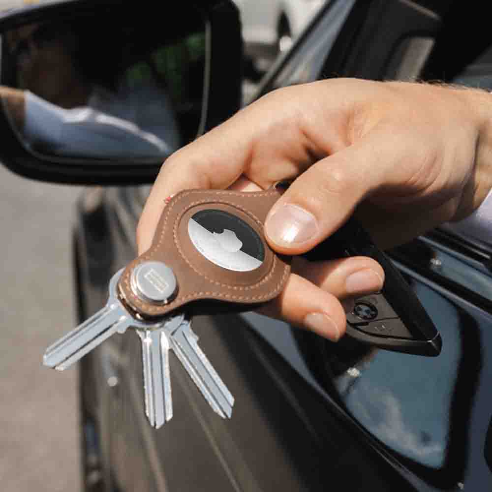 a hand holding the garzini airtag key holder