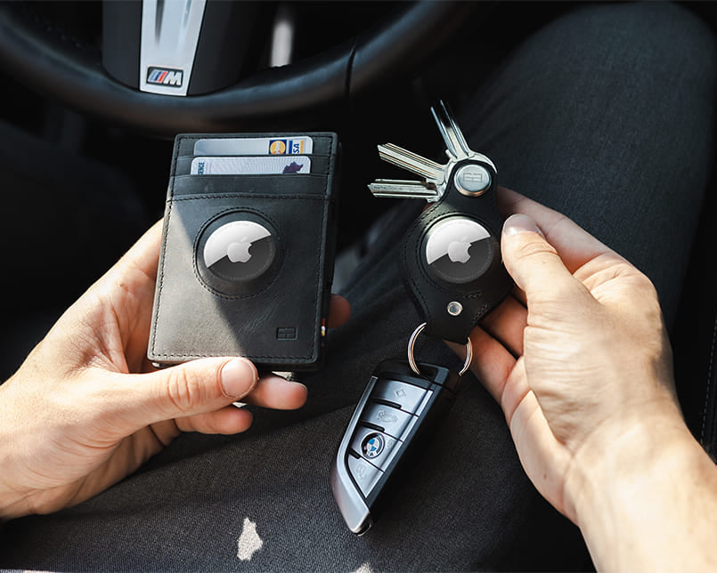 A hand holding the airtag key holder