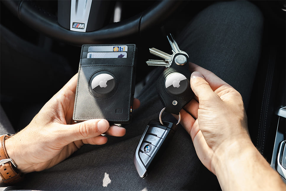 A hand holding the airtag key holder