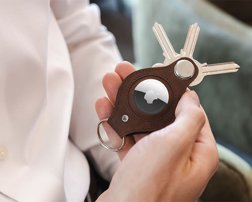 A hand holding the airtag key holder