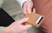 two hands holding the Garzini Essenziale Magic Wallet
