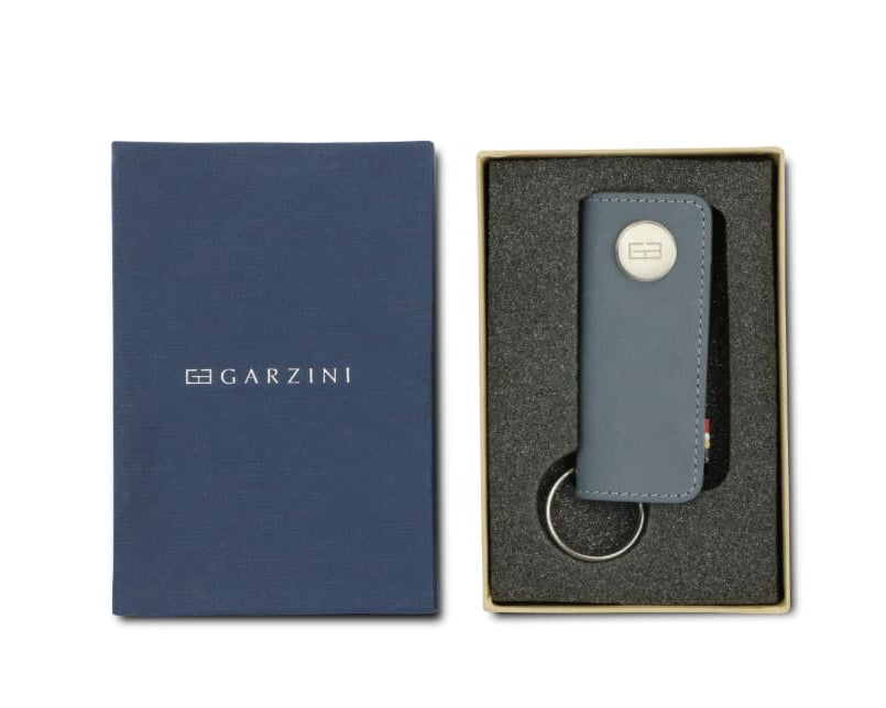 Front view of the Lusso Key Holder in Sapphire Blue in the box with the brand name Garzini. 
