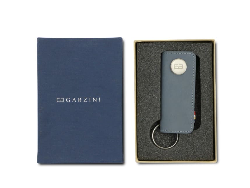 Front view of the Lusso Key Holder in Sapphire Blue in the box with the brand name Garzini. 