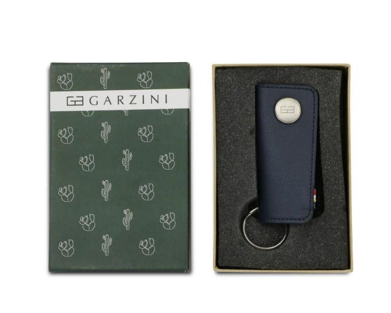 Open green box with the brand name and little cactus icons and front view of the Lusso Key Holder Vegan in Cactus Blue in the box