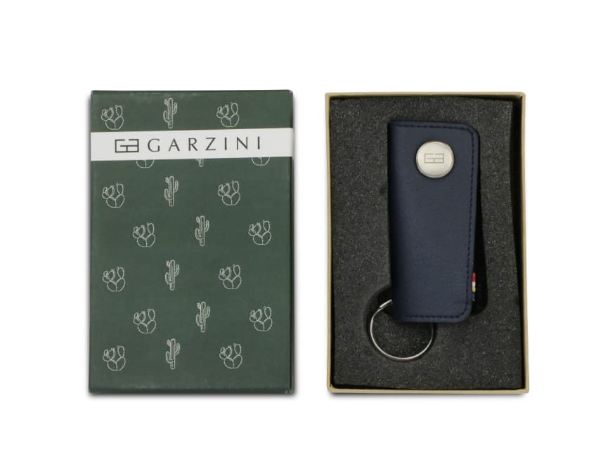 Open green box with the brand name and little cactus icons and front view of the Lusso Key Holder Vegan in Cactus Blue in the box