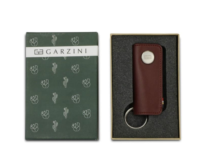 Open green box with the brand name and little cactus icons and front view of the Lusso Key Holder Vegan in Cactus Burgundy in the box