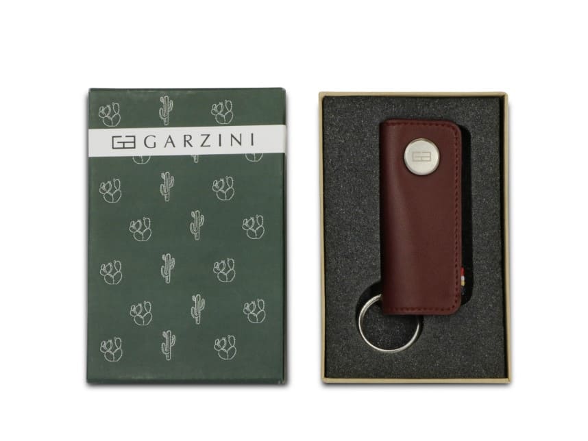 Open green box with the brand name and little cactus icons and front view of the Lusso Key Holder Vegan in Cactus Burgundy in the box