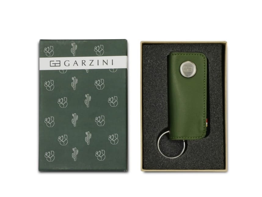 Open green box with the brand name and little cactus icons and front view of the Lusso Key Holder Vegan in Cactus Green in the box