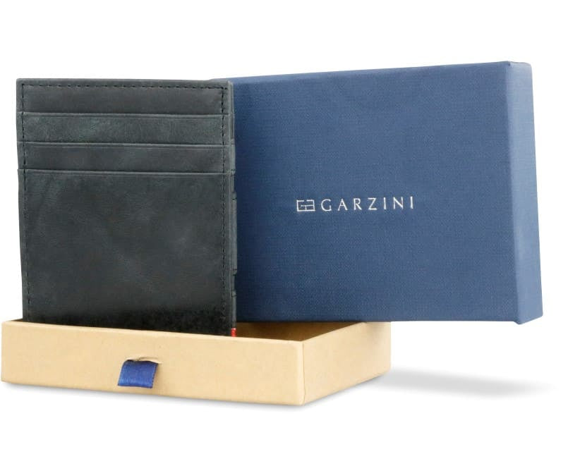 Half-open blue box with Garzini brand name Inside the box, the Brushed Black Wallet Brushed is wrapped in tissue paper, placed in a light cardboard box with a blue strap.