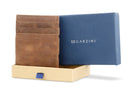 Half-open blue box with Garzini brand name Inside the box, the Brushed Brown Wallet Brushed is wrapped in tissue paper, placed in a light cardboard box with a blue strap.