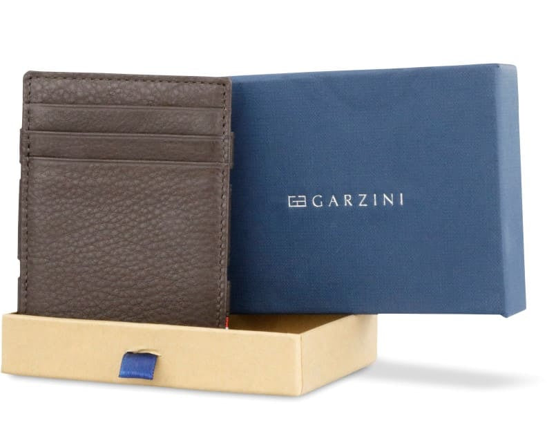 Half-open green box with Garzini brand name, featuring Nappa icons. Inside the box, the Nappa Chocolate Brown wallet is wrapped in tissue paper, placed in a light cardboard box with a green strap.