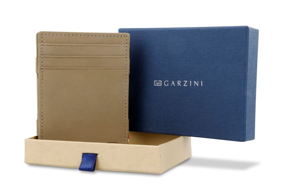 Half-open blue box with Garzini brand name Inside the box, the Metal Grey wallet is wrapped in tissue paper, placed in a light cardboard box with a blue strap.