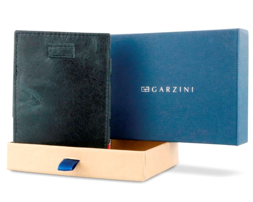 Half-open blue box with Garzini brand name Inside the box, the Brushed Black wallet is wrapped in tissue paper, placed in a light cardboard box with a blue strap.
