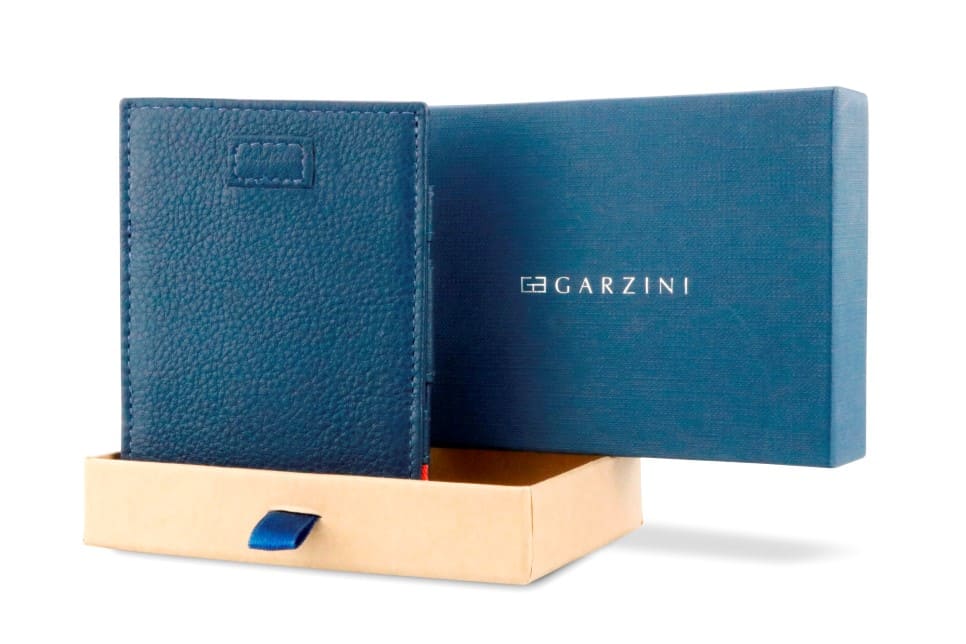 Half-open blue box with Garzini brand name Inside the box, the Navy Blue wallet is wrapped in tissue paper, placed in a light cardboard box with a blue strap.