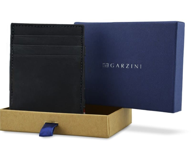 Half-open blue box with Garzini brand name. Inside the box, the Carbon Black wallet is wrapped in tissue paper, placed in a light cardboard box with a blue strap