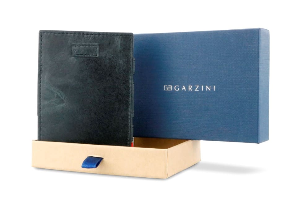 Half-open blue box with Garzini brand name Inside the box, the Brushed Black wallet is wrapped in tissue paper, placed in a light cardboard box with a blue strap.