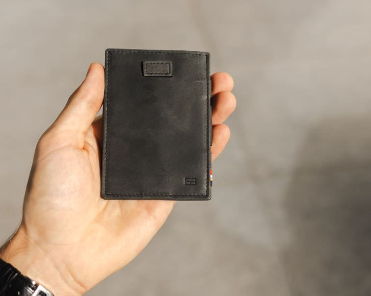 A hand holding the Garzini Cavare Brushed Black  wallet