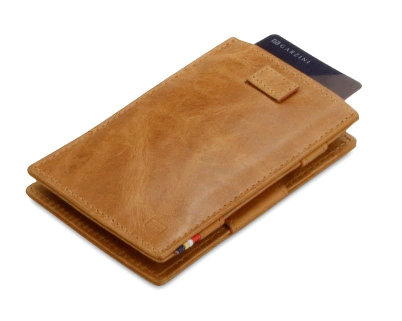 Front view of Cavare Magic Wallet Brushed in Brushed Cognac with pull tab and card pulling out.