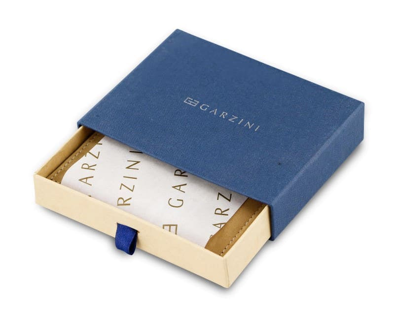 Half-open blue box with Garzini brand name Inside the box, the camel brown wallet is wrapped in tissue paper, placed in a light cardboard box with a blue strap.