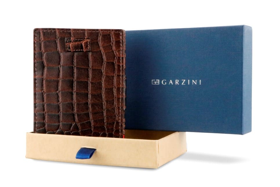 Half-open blue box with Garzini brand name Inside the box, the Garzini wallet is wrapped in tissue paper, placed in a light cardboard box with a blue strap.