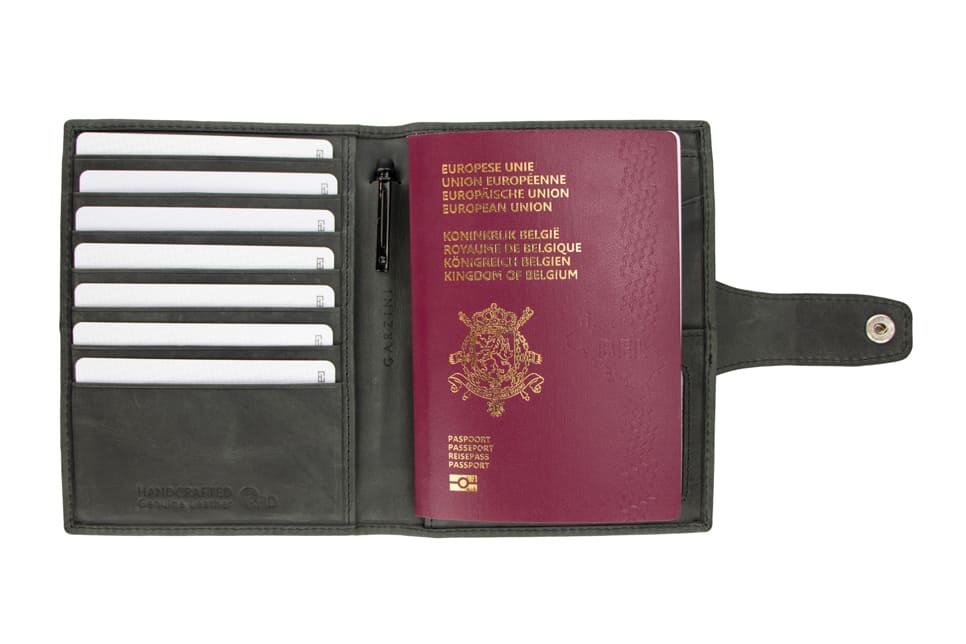 Open view of the AirTag Passport Holder in Brushed Brushed Black with cards and passport inside. 