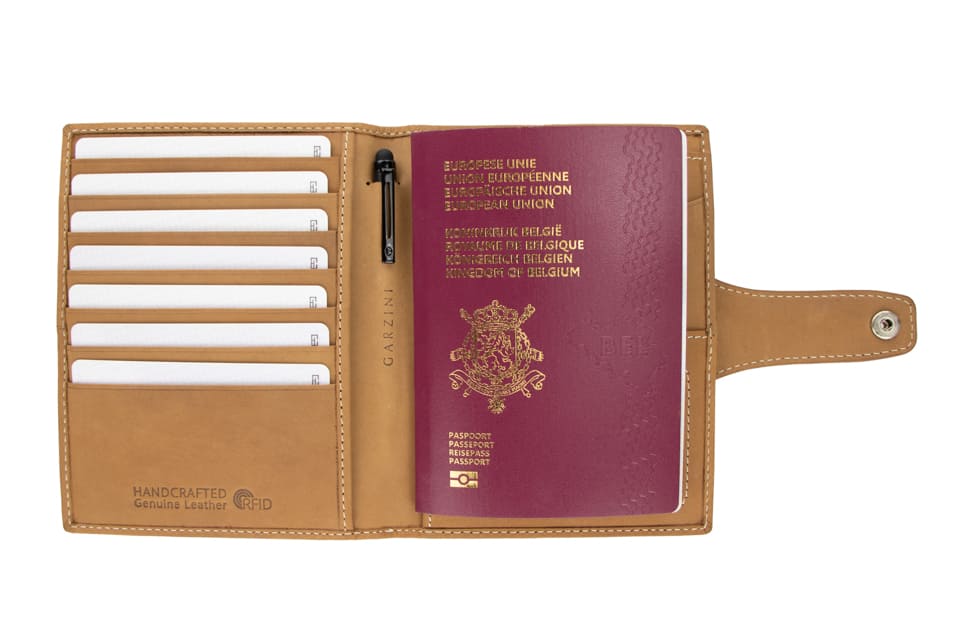 Open view of the AirTag Passport Holder in Vintage Camel Brown with cards and passport inside. 